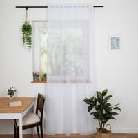 Weißer Vorhang am Fenster, lichtdurchlässig und elegant fallend in wohnlicher Umgebung.