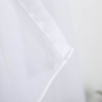 Nahaufnahme eines weißen, transparenten Voilestoffs mit weichem Fall und glattem Saum.