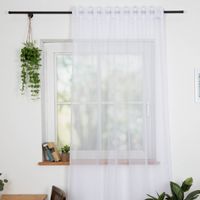 Gardinenstoff Stores Voile uni weiß transparent 2,6m Höhe Weißer Vorhang an schwarzer Stange, leicht fallend vor Fenster mit Pflanze und Büchern auf der Fensterbank.