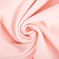 Detailaufnahme eines rosa Baumwollstoffes in spiraliger Anordnung zeigt feine Webstruktur.