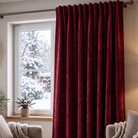 roter Thermovorhang aus Chenille im Wohnzimmer, bodenlang vor Fenster, stilvoll gefaltet, gemütliche Atmosphäre