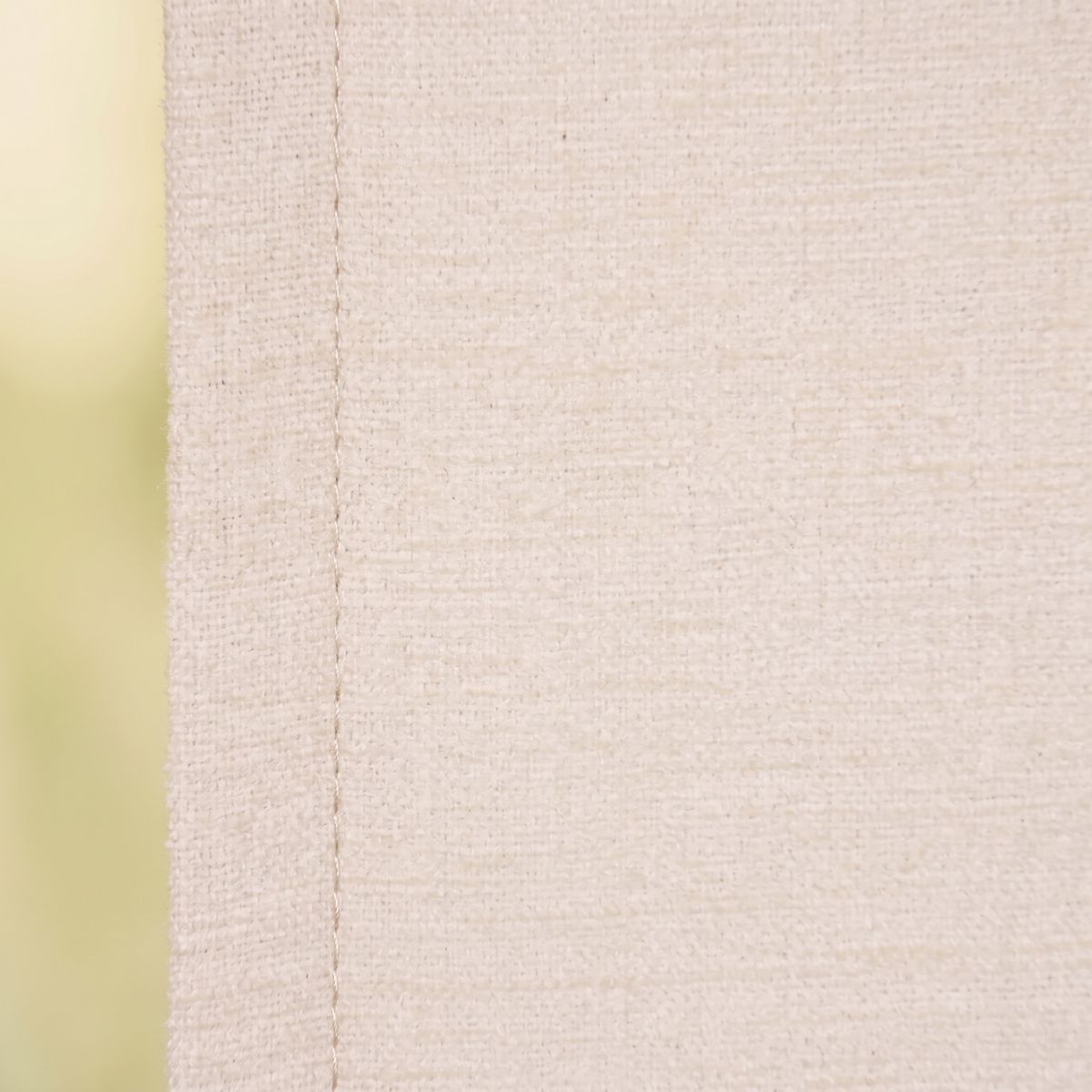 Nahaufnahme von wollweißem Chenille-Stoff mit sichtbarer Naht, kräftige Textur und feines Webmuster
