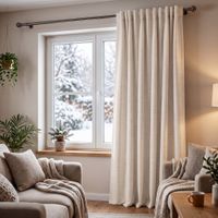 Wollweißer Thermovorhang aus Chenille im Wohnzimmer, bodenlang vor Fenster, winterliche Szenerie draußen