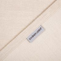 Ecke eines wollweißen Chenille-Stoffs mit sichtbarem Webband und SCHÖNER LEBEN-Label, Detailansicht