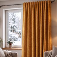 Thermovorhang Soft Teddy Deluxe ockergelb mit Smokband vor dem Fenster, weicher Faltenwurf im winterlichen Wohnzimmer
