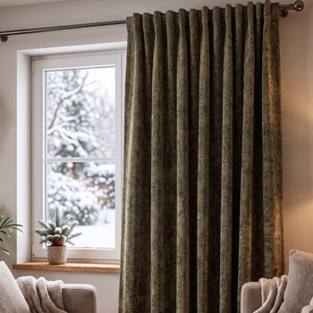 Thermovorhang Soft Teddy Deluxe moosgrün mit Smokband vor dem Fenster, weicher Faltenwurf im winterlichen Wohnzimmer