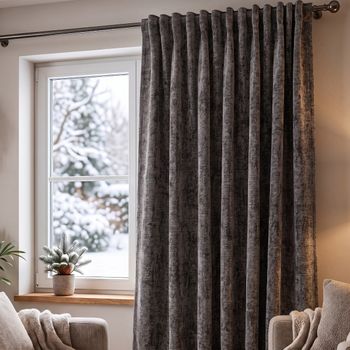 Thermovorhang Soft Teddy Deluxe grau mit Smokband vor dem Fenster, weicher Faltenwurf im winterlichen Wohnzimmer