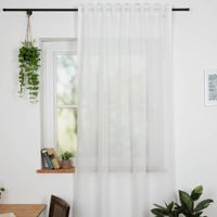 Gardinenstoff Gardinenstores zarte Leinenstruktur weiß Meterware 260cm hoch Weisser Vorhang vor Fenster, weich fallend, neben hängenden Pflanzen und Bücher auf der Fensterbank.