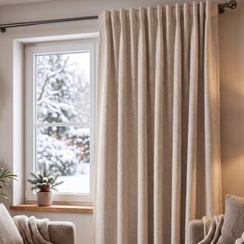 Thermovorhang Doppelgewebe hellgrau meliert mit Smokband vor dem Fenster, weicher Faltenwurf im winterlichen Wohnzimmer