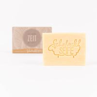 85484-La-Vida-Naturkosmetik-Schafmilchseife-Die-beste-Zeit-ist-jetzt-Federn-grau-100g-KW34-2023-018-2.jpg Schafmilchseife mit eingeprägtem Schriftzug, Geschenkverpackung im Hintergrund