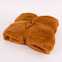 camelbraune Plüschdecke zusammengefaltet und mit Schleife zusammengebunden