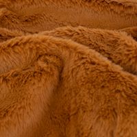 camelbraune Plüschdecke zusammengefaltet und mit Schleife zusammengebunden