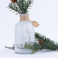 Detailaufnahme Vase mit transparenter Häuserreihe mit durchscheinenden Tannenzweig im Hintergrund