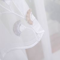 Gardinenstoff Voile Stickerei Fransen Blumen Bogenkante weiß grau beige 280cm Breite Nahaufnahme von weissem transparentem Stoff mit eleganter Stickerei in Beige und Grau.