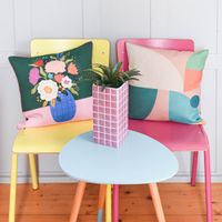 mit Keder mit Blumenvase in bunt grün rosa detail dekoriert auf stuhl mit anderem Kissen und Vase