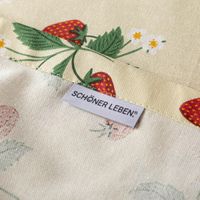 88844-Tischdecke-Strawberry-Happy-Fruit-Erdbeeren-vanille-rot-gruen-in-versch--Groessen-von-SCHoeNER-LEBEN--117590-007.jpg Saumdetail der Tischdecke Strawberry Happy Fruit aus Baumwolle mit Markenlabel von SCHÖNER LEBEN.
