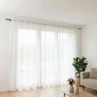 Zeitlose Gardine in Wollweiß mit natürlicher Leinenstruktur und praktischem Smok-Schlaufenband. Der transparente Stoff sorgt für eine helle Atmosphäre und dezenten Sichtschutz – in verschiedenen Größen erhältlich - Vollansicht im Raum praesentiert