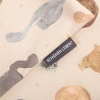 Detailansicht der Kissenhülle mit Katzenmotiv und SCHÖNER LEBEN Label auf Baumwollstoff in Natur.