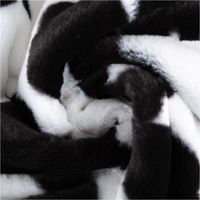 Kuschelweiches Plüsch Stoff Fellimitat im Kuhfell-Look in Schwarz und Weiß mit 1,60m Stoffbreite drapiert