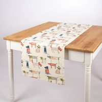 Dekorativer Tischläufer Baumwolle Hunde beige bunt 40x160cm von SCHÖNER LEBEN locker über Tischkante drapiert.