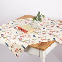 Baumwoll-Mitteldecke mit bunten Hunde-Motiven in Beige von SCHÖNER LEBEN, stilvoll mit Buch und Vase inszeniert