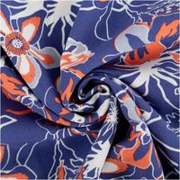 Leichter Viskose Popeline Stoff mit Blumen-Muster in Blau und Orange, 145 cm breit. Weich, atmungsaktiv, hautfreundlich – ideal für Blusen, Kleider & Sommer-Outfits kunstvoll eingedreht in Falten