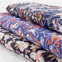 Leichter Viskose Popeline Stoff mit Blumen-Muster in Blau und Orange, 145 cm breit. Weich, atmungsaktiv, hautfreundlich – ideal für Blusen, Kleider & Sommer-Outfits mit anderen Stoffen in Szene gesetzt Vollbild