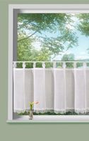 Szenerie mit Scheibengardine aus Voile mit Makramee-Schlaufen & Spitzenborte, 45x140 cm. Transparent, pflegeleicht & auch in 30 cm Höhe erhältlich. Die Gardine hängt an einer Scheibenstange mittig am Fenster in schönen Wellen