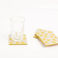 Verschönere deinen Tisch mit diesem charmanten 4er Set Zitronen-Untersetzer von Sass & Belle. Das fröhliche Design zeigt gelbe Zitronen auf hellem Grund und schützt Oberflächen stilvoll vor Flecken - mit Glas praesentiert