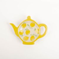 91601-Teller-Zitronen-Lemon-Tea-Bag-Rest-Teekannenform-von-Sass-und-Belle-IMG-1547.jpg Diese dekorative Teebeutelablage von Sass & Belle in verspielter Teekannenform ist das ideale Accessoire für jede Teestunde. Die kleine Keramikschale mit sonnigem Zitronen-Motiv sorgt für Ordnung am Tisch und fängt benutzte Teebeutel stilvoll auf - Nahaufn