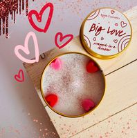 91832-Duftkerze-Bear-Hug-Scent-Stories-Candle-in-der-Metalldose-von-Bomb-Cosmetic--Screenshot-2025-05-27-195601.jpg Big Love Kerze offen mit Dekoration, fotografiert auf Holzuntergrund mit Herzillustrationen