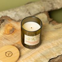Duftkerze von oben – brennend, Glas mit Etikett auf natürlichem Hintergrund