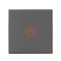 Oberseite der Verpackung mit Aufdruck Soy Wax Candle in a Concrete Pot in Orange auf dunkelgrauem Grund