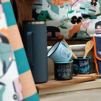 91876-Tasse-Emaille-Camp-Explore-Discover-von-Gentlemen--s-Hardware-Camper2025--5-von-16-.jpg Hellblaue Emaille-Tasse mit Aufdruck Camp Explore Discover steht auf einer anderen Tasse im Campervan