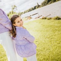 Mutter und Tochter mit Jacken aus fliederfarbenem Steppstoff am See