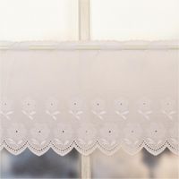 92083-Scheibengardinen-Meterware-Batist-Stickerei-Blumen-weiss-27cm-Hoehe-IMG-2873.jpg Weiße Batist-Scheibengardine mit gestickten Blumen und welligem Rand, präsentiert am Fenster als zarte Meterware in 27 cm Höhe - Nahaufnahme am Fenster