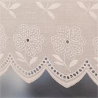 92083-Scheibengardinen-Meterware-Batist-Stickerei-Blumen-weiss-27cm-Hoehe-IMG-2875.jpg Weiße Batist-Scheibengardine mit gestickten Blumen und welligem Rand, präsentiert am Fenster als zarte Meterware in 27 cm Höhe - Detailaufnahme