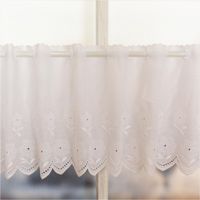 92083-Scheibengardinen-Meterware-Batist-Stickerei-Blumen-weiss-27cm-Hoehe-IMG-2878.jpg Weiße Batist-Scheibengardine mit gestickten Blumen und welligem Rand, präsentiert am Fenster als zarte Meterware in 27 cm Höhe - Nahaufnahme gerafft