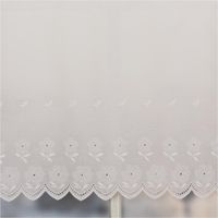 Weiße Batist-Scheibengardine mit floral besticktem Saum und Wellkante, präsentiert am Fenster als zarte Meterware in 47 cm Höhe - Detailaufnahme