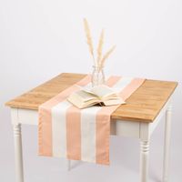 Peach-ecru gestreifter Tischläufer 40x160 cm dekoriert auf Holztisch mit Vase und Buch.