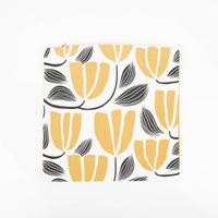Kissenhülle aus Canvas mit abstraktem Blumenmuster in Gelb, Ecru und Schwarz auf weißem Hintergrund - zusammengefaltet