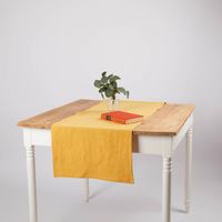 Tischläufer aus Leinen mit Baumwollanteil in einfarbigem Gelb, Größe 40x160 cm, dekorativ auf einem Holztisch arrangiert - in Szene gesetzt