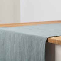 Tischläufer aus Leinen mit Baumwollanteil in einfarbigem Altgrün, Größe 40x160 cm, dekorativ auf einem Holztisch präsentiert - Detailaufnahme