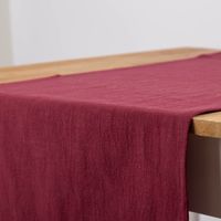 Tischläufer aus Leinen mit Baumwollanteil in einfarbigem Beerenton, Größe 40x160 cm, dekorativ auf einem Holztisch arrangiert - Detailaufnahme