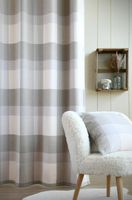 92270-Vorhangstoff-Wolloptik-Landhauskaro-weiss-beige-140cm-Breite-Screenshot-2025-07-26-113113.jpg Raumansicht mit beige-weiß kariertem Vorhang und passendem Kissen im Landhausstil