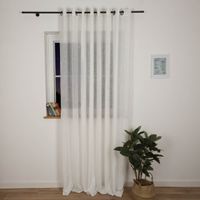Ösenvorhang Ontario XL 290x260 cm in Wollweiß, bei Nacht präsentiert im eingerichteten Wohnraum – dezenter Stoff für sanften Lichteffekt und stilvolle Fensterdekoration