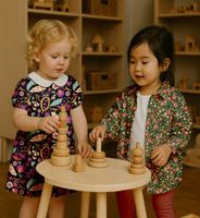 Zwei Kinder spielen, eines trägt ein Kleid aus Feincord Stoff mit Blumen-Print schwarz-lila