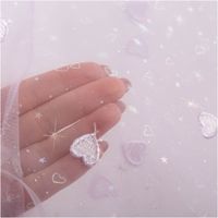 92602-Tuell-Stoff-Herzchen-Stickerei-und-Glitzer-lila-125cm-Breite-IMG-8528.jpg Transparenter Tüllstoff mit lila Herzchen-Stickerei und glitzernden Details auf hellem Grund - mit hervorgehobener Transparenz