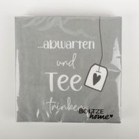 erviettenpackung in Grau mit der Aufschrift „…abwarten und Tee trinken“, präsentiert mit gezeichnetem Teebeutel-Motiv und dezenter Struktur, in Szene gesetzt vor hellem Hintergrund – 3-lagige FSC-Papier-Servietten von Boltze Home - Nahaufnahme