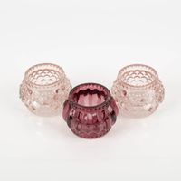 Dekoratives Set von Boltze mit drei Teelichthaltern aus Glas. Die bauchigen Halter sind in verschiedenen Rosatönen gehalten und mit einem erhabenen Punkt- oder Rillenmuster verziert. Jeder Halter ist 7×5 cm groß und sorgt für stimmungsvolles Licht - Nahauf